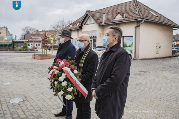 Delegacja Urzędu Miasta Nowego Sącza składająca wiązankę pod tablicą memoratywną poświęconą Sądeckim Żołnierzom Wyklętym na budynku dworca PKP.