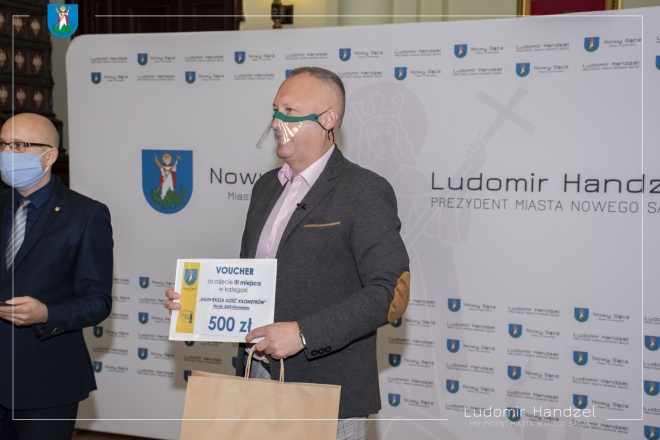 Zdjęcie Prezydenta Miasta Ludomira Handzla przekazującego nagrody.