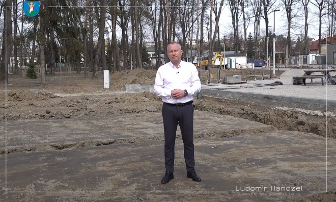 Prezydent Ludomir Handzel na tle prac związanych z boiskiem wielofunkcyjnym.