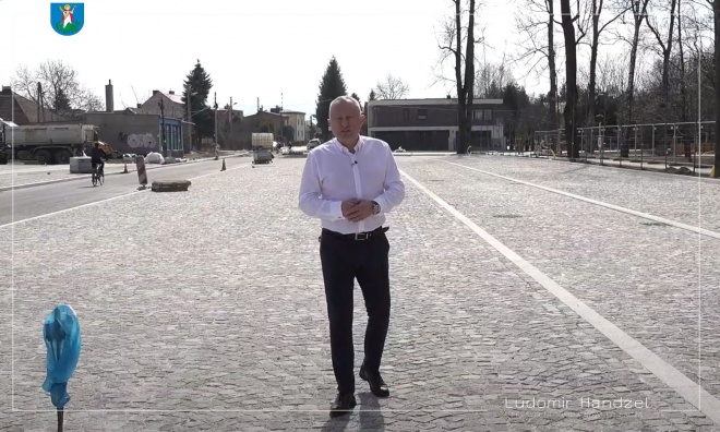 Prezydent Ludomir Handzel stoi na parkingu przy Parku Strzeleckim.